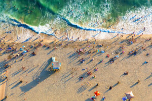 aerial view of a beach with beachgoers, during sunset