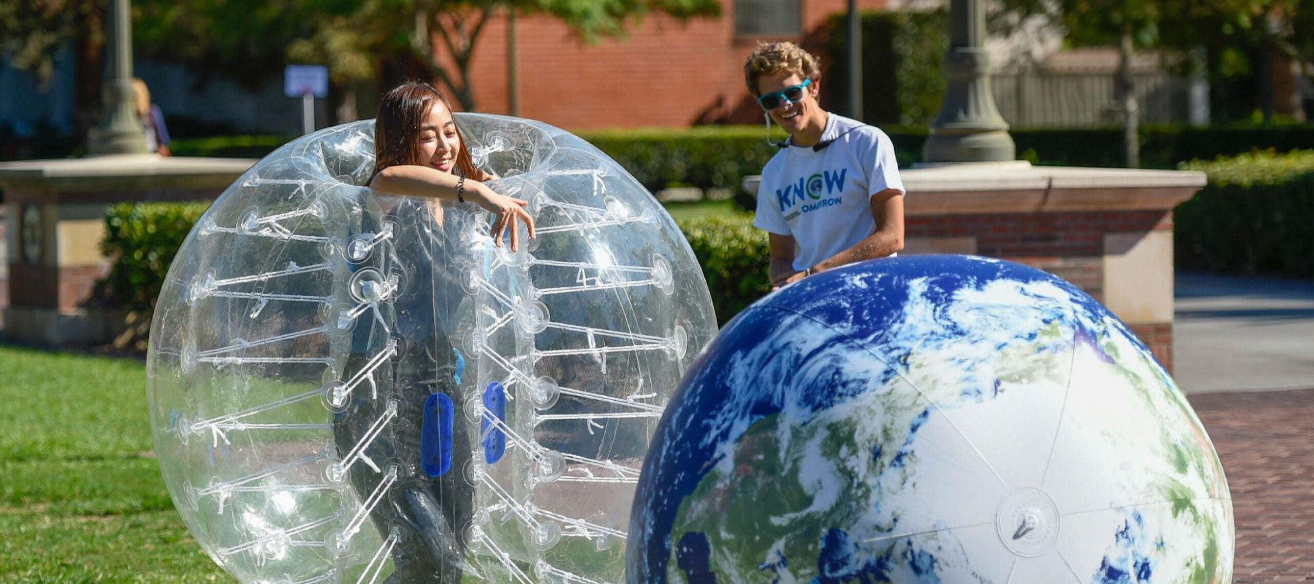 Students playing with an inflatable globe on USC campus.