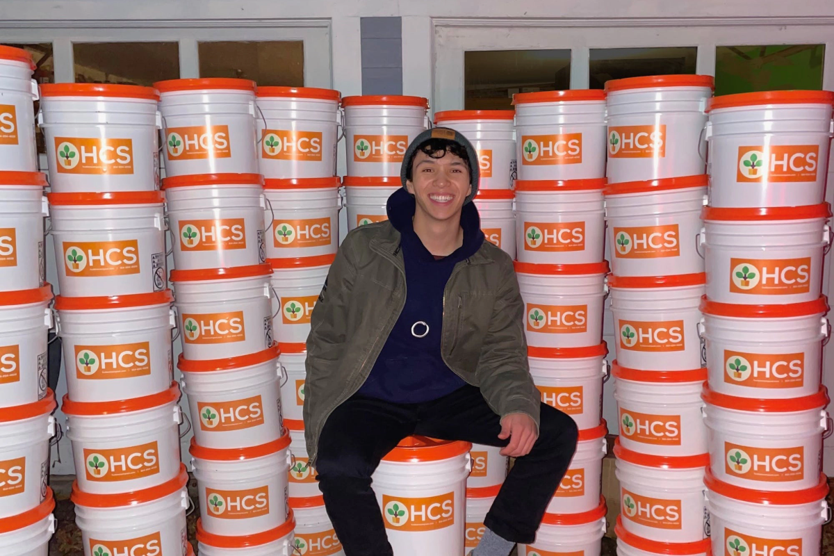 USC Iovine and Young Academy alumni Ben Wan in front of compost buckets.