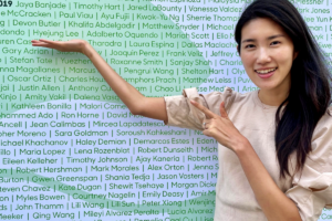 Hyejung “Hazel” Lee posing in front of a list of names at Beyond Meat.