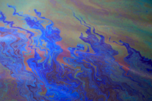An oil slick spreads across surface waters.