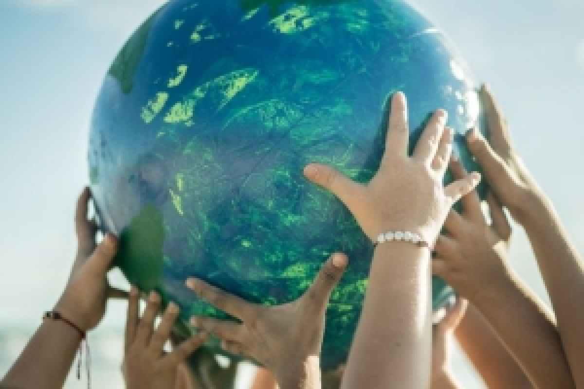 Many hands holding up a globe.
