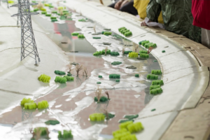 A small-scale model of a section of the LA River with trees and vegetation.