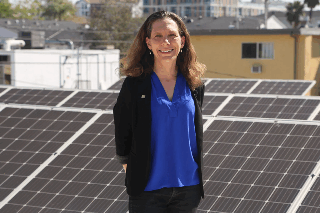 Zelinda Welch posing in front of solar panels.